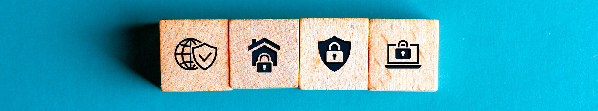 4 Bausteine aus Holz mit Sicherheitssymbolen. Blauer Hintergrund